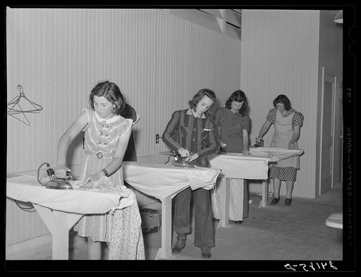 Ironing clothes in utility building. Tulare migrant camp. Visalia, California