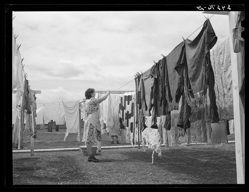 Woman hanging clothes to dry. Tulare migrant camp. Visalia, California