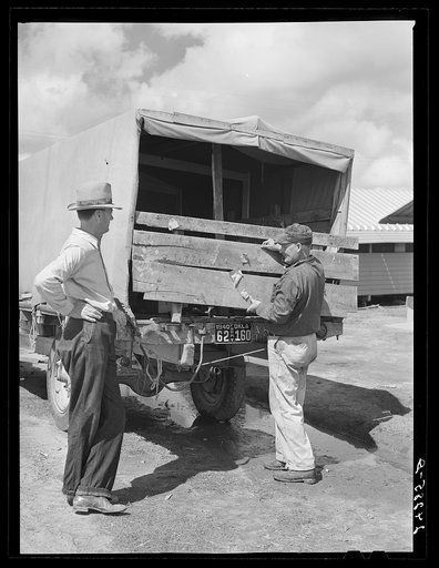 Migrant, returning to Oklahoma, repairs truck. Tulare migrant camp. Visalia, California