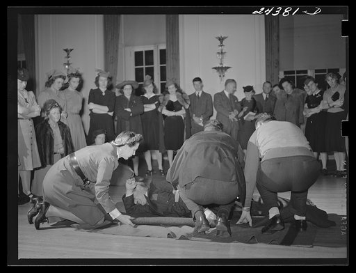 Untitled photo, possibly related to: Civilian defense volunteers receiving instruction in proper care for man with spine injury. First aid class. New York City