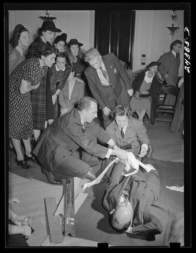 Civilian Defense volunteers receiving instruction in treatment of fractured arm. First aid class. American Red Cross, New York City