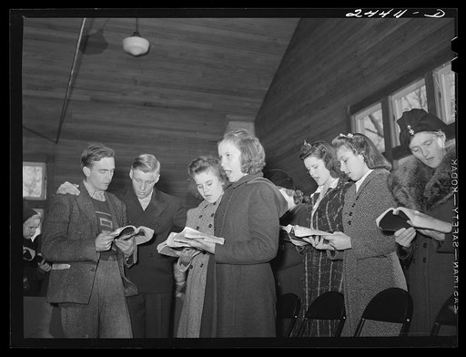 Untitled photo, possibly related to: Group singing hymns at the opening of the Sunday school. While there are no churches on the project there are five or six in the area close by. This one is just off the project and is attended by many project members. Dailey, West Virginia