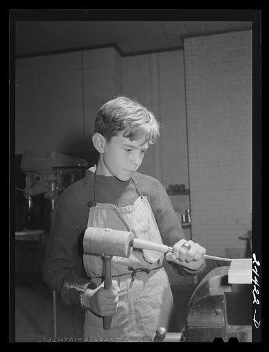 Boy grooving wood in shop class at homestead school. Dailey, West Virginia