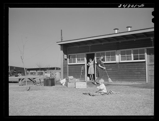 Camper sweeps sidewalk in front of her shelter. FSA (Farm Security Administration) camp, Robstown, Texas