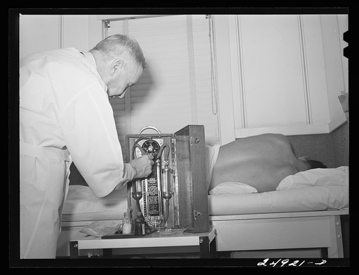 Untitled photo, possibly related to: Corpus Christi, Texas. Privately supported tuberculosis clinic supervised by a retired doctor. Majority of patients are Latin-American. Doctor recording medical history of patient. Map shows number of cases in area