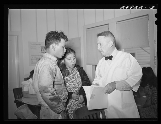Untitled photo, possibly related to: Corpus Christi, Texas. Privately supported tuberculosis clinic supervised by a retired doctor. Majority of patients are Latin-American. Doctor recording medical history of patient. Map shows number of cases in area