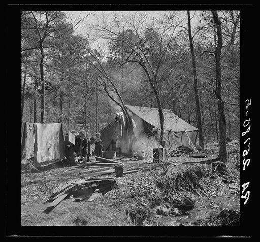 Tent occupied by sharecropper family now living in a migrant camp near Birmingham, Alabama. Note water supply at right
