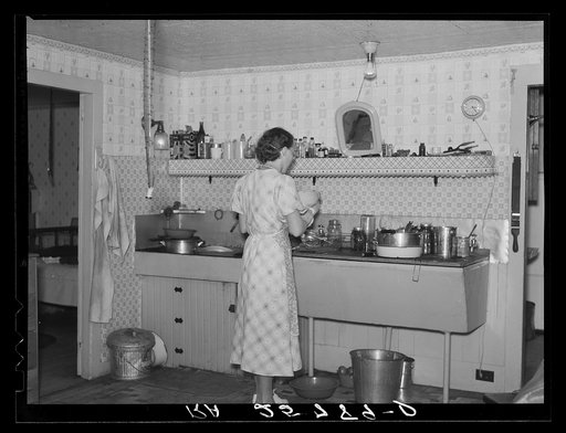 Hired girl washing dishes on the McNally farm. Kirby, Vermont