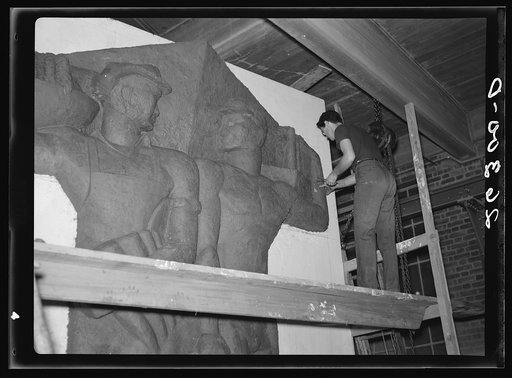 Washington, D.C. Vernon Atchely of the Special Skills division of the U.S. Resettlement Administration working on figures modeled in relief for the Greendale school
