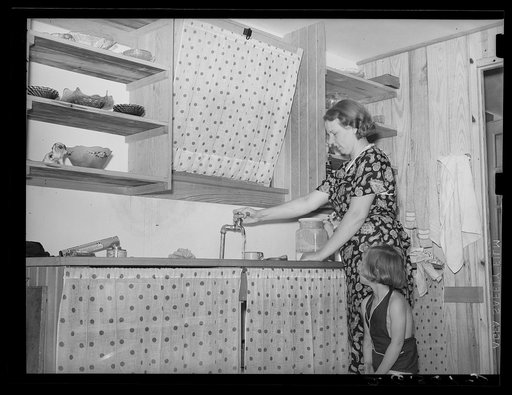 Resettled farmer's wife and daughter in kitchen of new home. Wabash Farms, Indiana