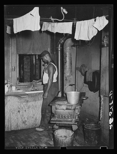 Steel worker in kitchen of slum apartment. Midland, Pennsylvania