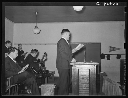 Preacher conducting hymn singing. Pentecostal church, Cambria, Illinois