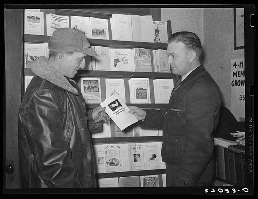 Rehabilitation Administration supervisor presenting agricultural pamphlet to farmer. Ridgeway, Illinois