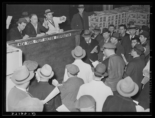 Buyers at auction of fruit and vegetables at produce market. Pier 29, New York City