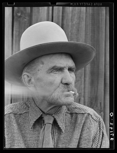 Frank Latta, pioneer cowpuncher, smoking hand-rolled cigarette. Bozeman, Montana