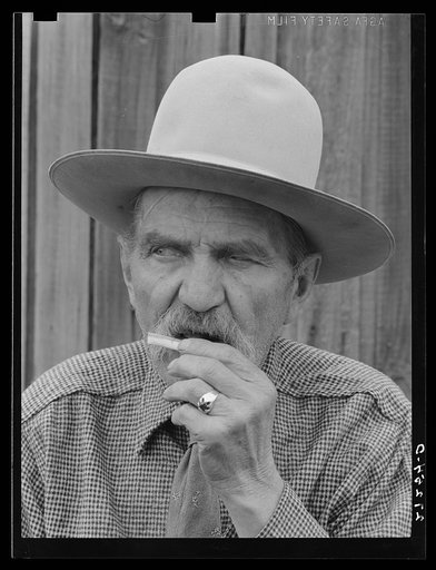 Frank Latta moistening a hand-rolled cigarette. Bozeman, Montana