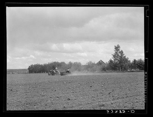 Farmer and wife operationg tractor and seed drill. Fairfield Bench Farms, Montana