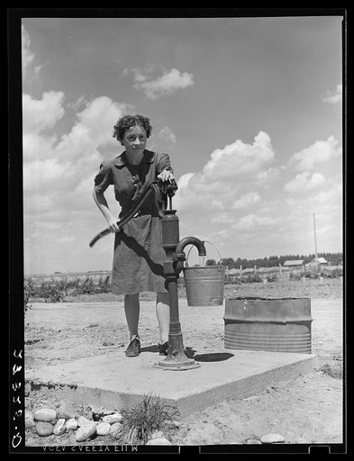 Farm girl pumping water. Fairfield Bench Farms, Montana