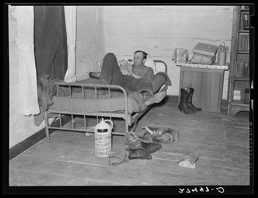 Cowhand at ease in bunkhouse. Quarter Circle 'U' Ranch, Montana
