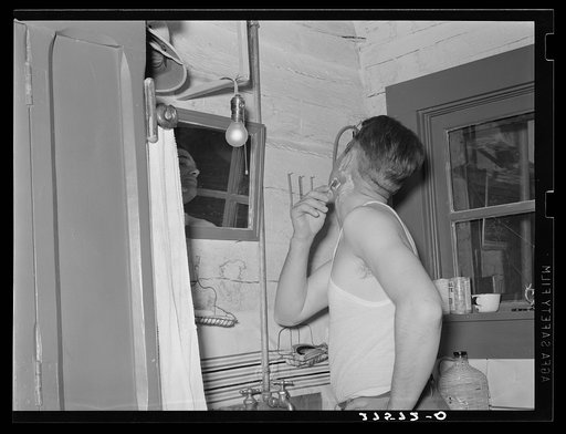Cowhand shaving. Quarter Circle 'U' Ranch, Montana