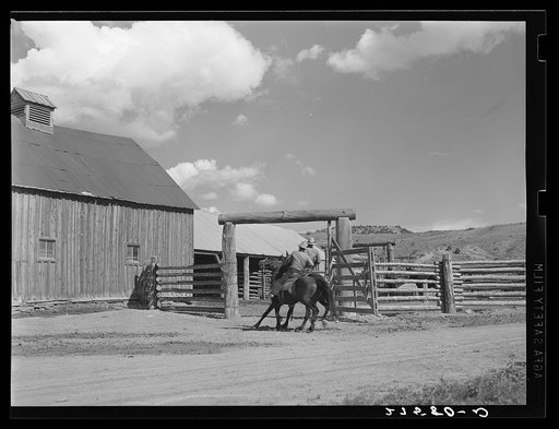 Untitled photo, possibly related to: Ranchers riding through corral gate. Quarter Circle 'U' Ranch, Montana