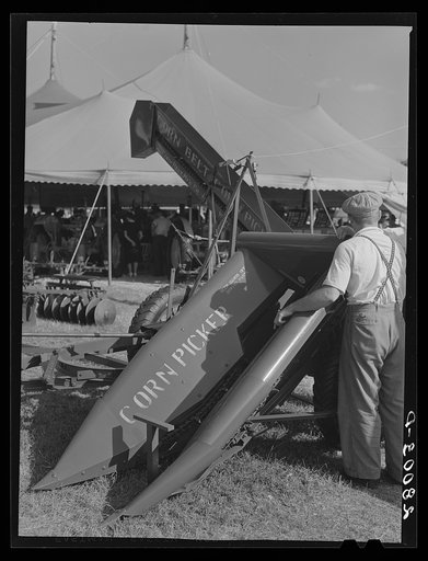 Untitled photo, possibly related to: Farmers examine new corn picker at Iowa State Fair. Des Moines, Iowa