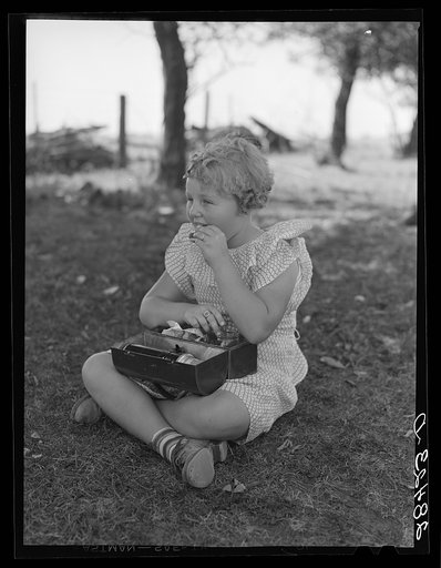 Schoolgirl, pupil of one-room schoolhouse, eating lunch. Grundy County, Iowa