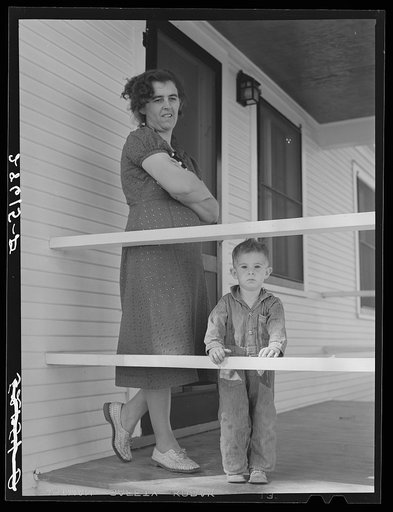 Mrs. Carl Higgins, wife of Mesa County, Colorado, tenant purchase borrower, and son on porch of their farmhouse