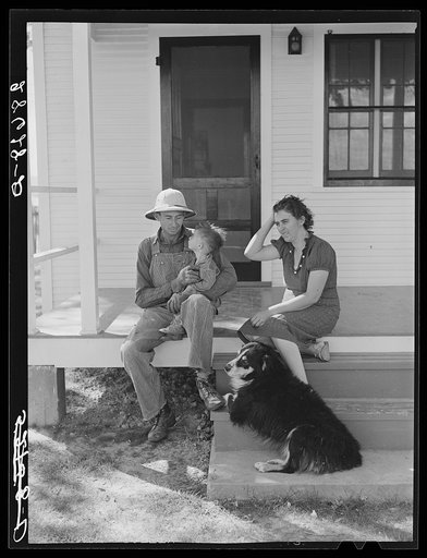 Carl Higgins family, purchase borrowers, on the porch of their home in Mesa County, Colorado