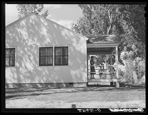 Mrs. Carl Higgins, wife of tenant purchaser, and son on porch of home. Mesa County, Colorado