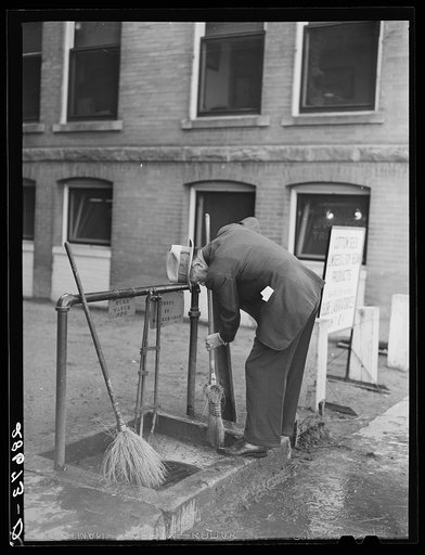 Untitled photo, possibly related to: Cattle buyer cleaning his shoes after trip through the stockyards. Denver, Colorado