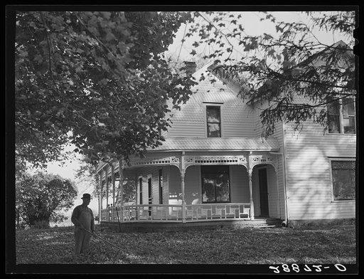 Untitled photo, possibly related to: Farmer raking leaves on lawn of his home. Grundy County, Iowa