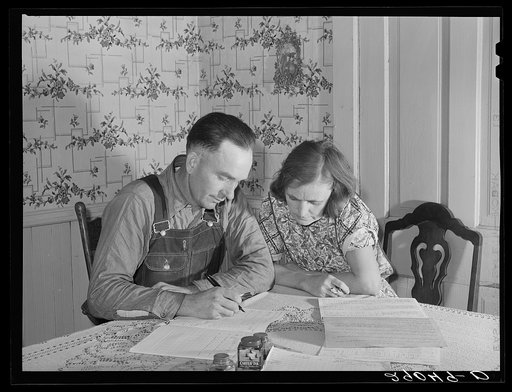 Fred Wilfang, rehabilitation client, goes over his farm plan with his wife. They have twenty hogs, ten milk cows, 250 chickens, a tractor, a bull and 500 quarts of canned goods. Black Hawk County, Iowa