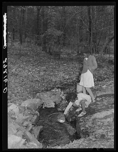 Daughter of evicted sharecropper getting water at spring. Butler County, Missouri