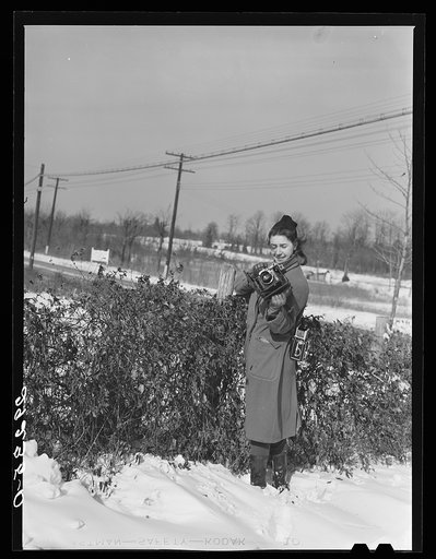 Untitled negative showing Marion Post Wolcott standing in snow with cameras at a farm in Montgomery County, Maryland