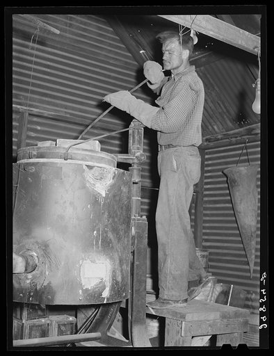 Stirring molten gold and silver in furnace. El Dorado Canyon, Nevada
