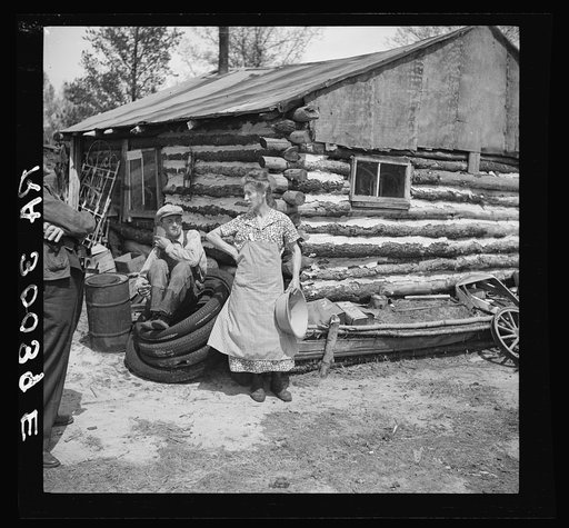 Mrs. Hale and her oldest son in front of their home near Black River Falls, Wisconsin. This farm house was built with a total expenditure of three dollars in money