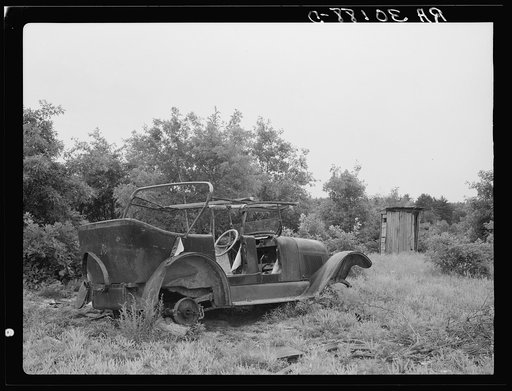 Old automobile and outhouse on Art Simplot's farm near Black River Falls, Wisconsin