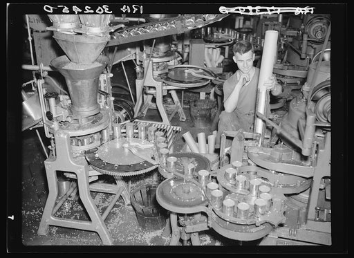 Empty cans are filled with peas and lids placed on them. Canning factory, Sun Prairie, Wisconsin