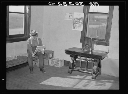 Old resident of corner of beer parlor. Gemmel, Minnesota. Former prosperous lumbering center. Note sign and battery-operated radio