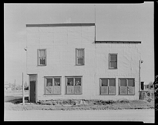 Front of old hotel. Gemmel, Minnesota. Lower part is occupied by an old woman