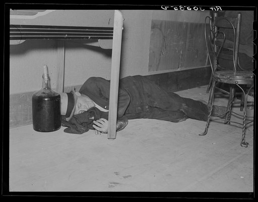 Lumberjack under the table in a saloon. Craigville, Minnesota