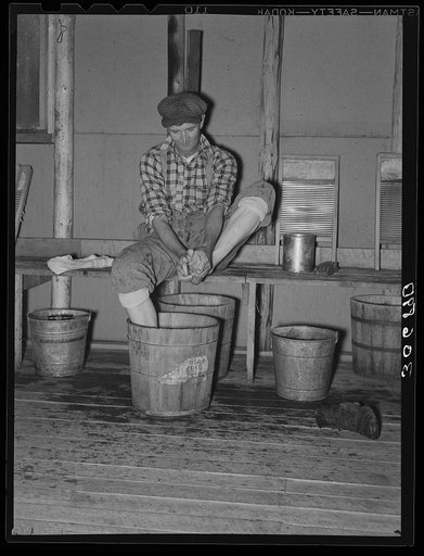 Lumberjack washing his feet. Camp near Effie, Minnesota