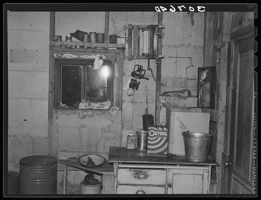Kitchen in dust storm area with window sealed with towels. Williams County, North Dakota