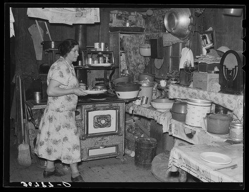 Mrs. Ole Thompson, wife of farmer, carrying food to the table. Williams County, North Dakota