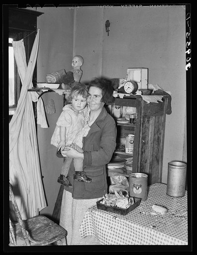 Mother and child in corner of farm home. Sheridan County, Montana