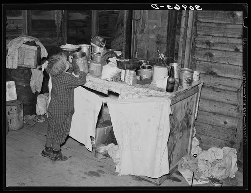 Little girl in kitchen of farm home. Sheridan County, Montana