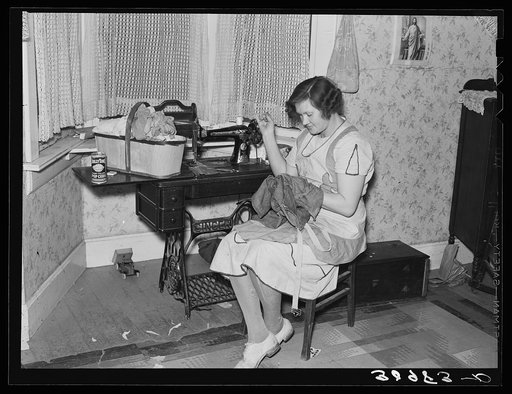 Mrs. Carl Thorson patching clothes in home. Crosby, North Dakota