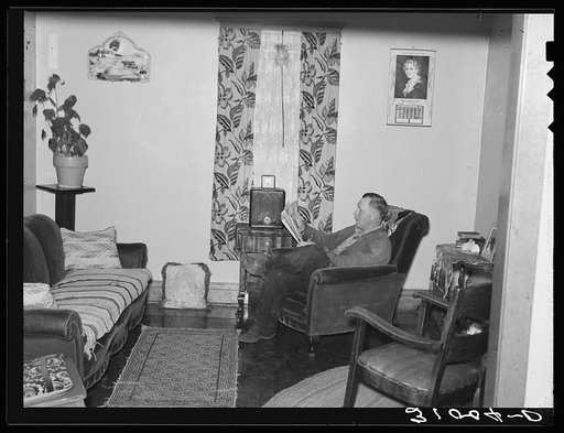 Mr. Jorgenson reading in his living room near Crosby. Divide County, North Dakota