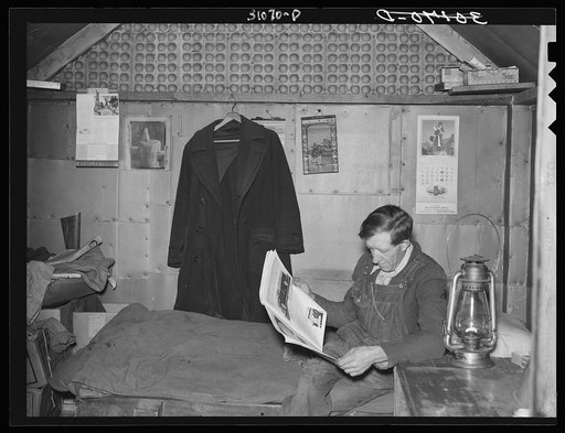 Gold miner reading in his shack. Two Bit Creek, South Dakota